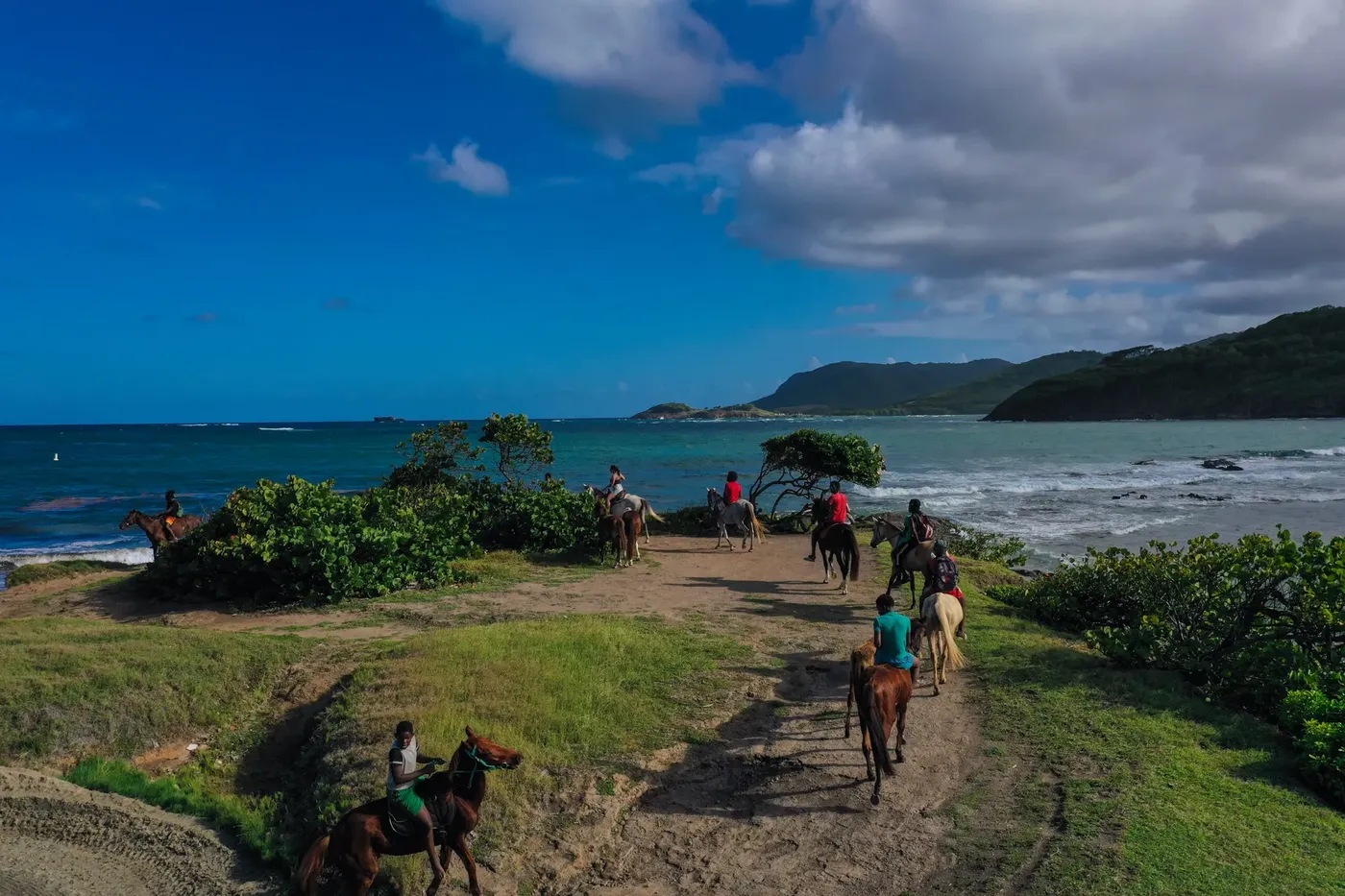 Aerial view of riders on the sandy trail down to Cas en Bas beach